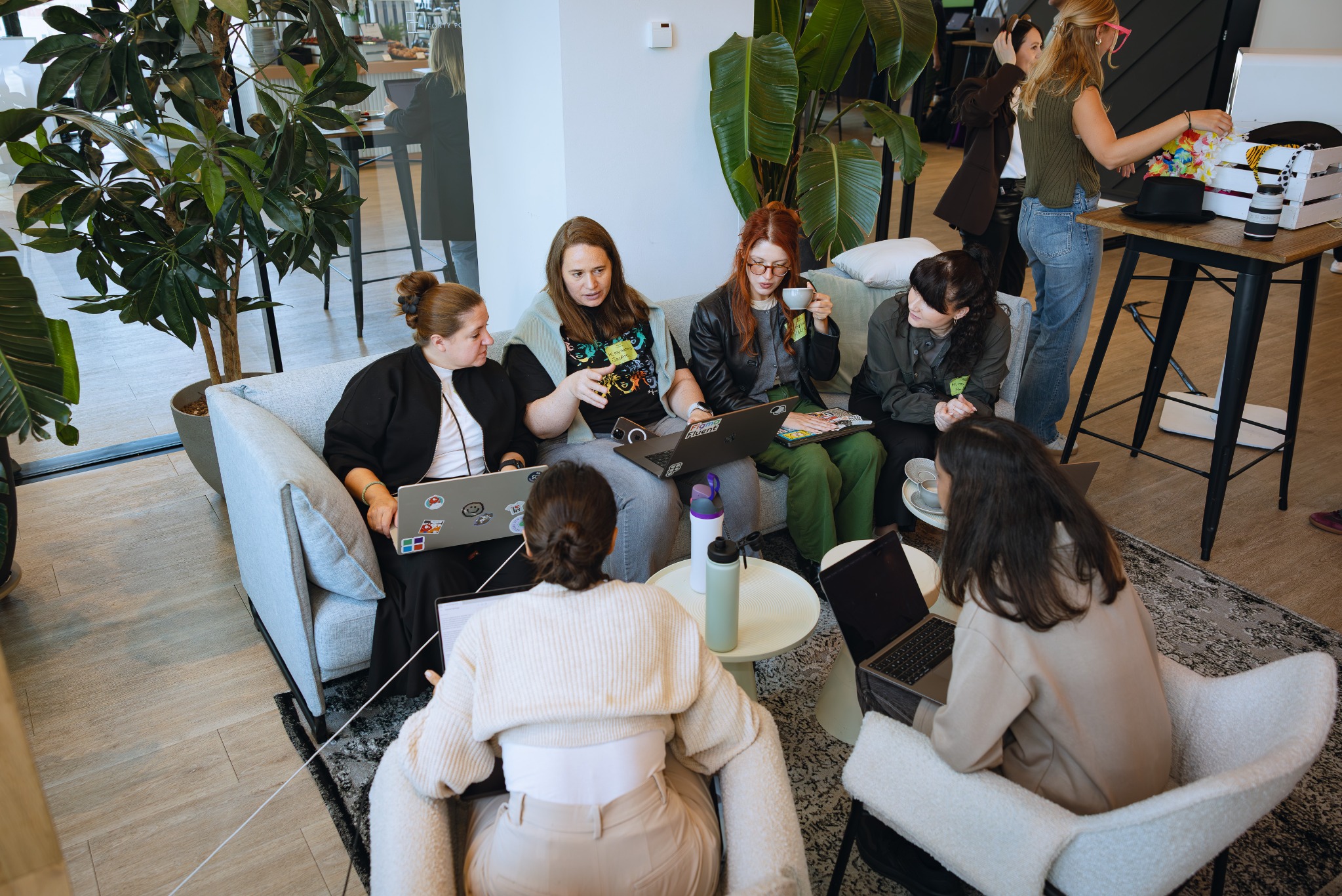 People sharing ideas around laptops at a creative meetup.