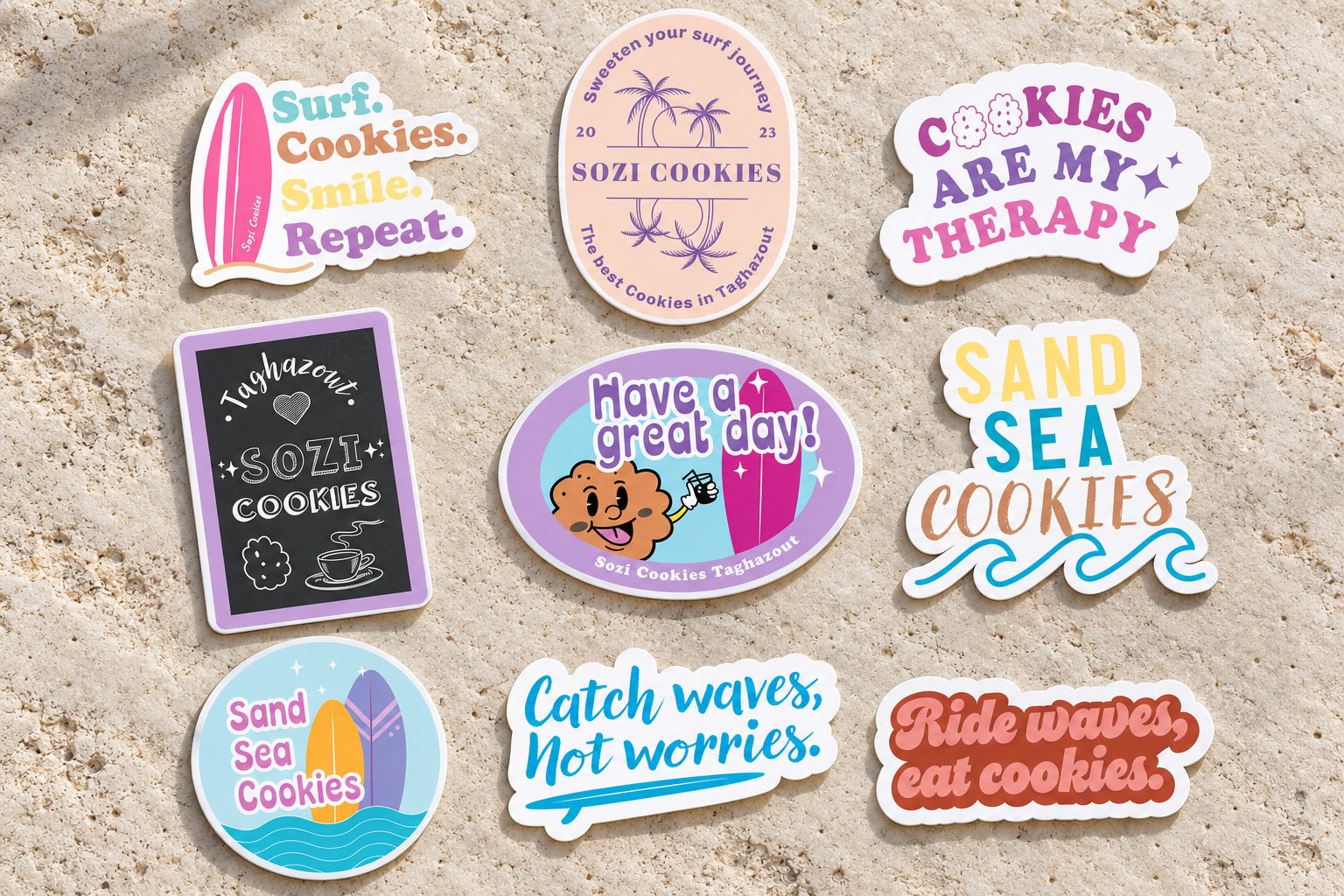 All nine Sozi Cookies surf and cookie sticker designs on light coastal limestone
